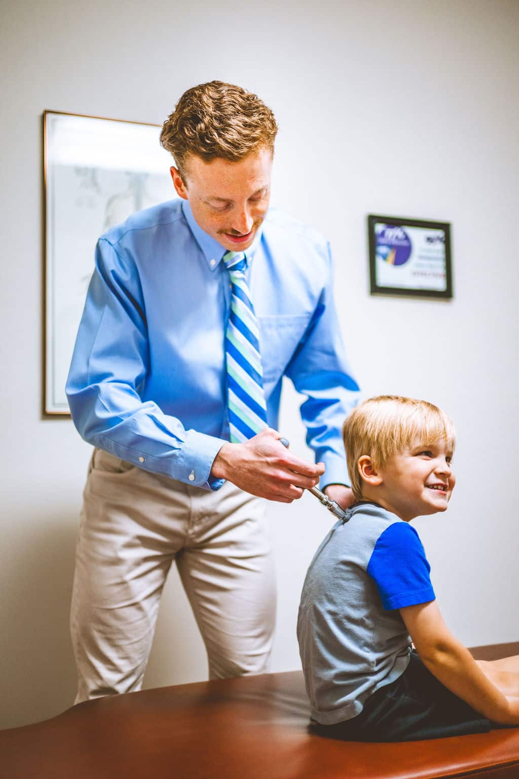 Child receiving chiropractic care in Auburn, AL clinic. Chiropractor helps young patients.