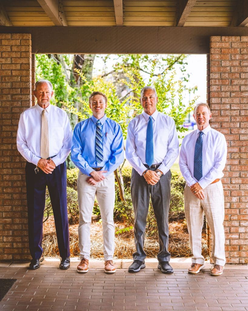 Four professionals standing together, representing a trusted chiropractor in Opelika, AL.